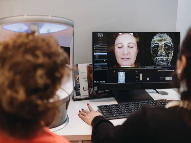 Zwei Frauen betrachten eine medizinische Darstellung auf einem Monitor.